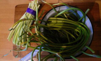 Com cuinar fletxes d'all fregides? Per fregir, només necessitareu la part verda dels brots; talleu la floració i les parts blanques inferiors. 