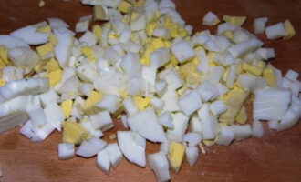 Se fierb ouăle fierte tari. Lăsați-le să se răcească complet și tăiați-le în cuburi ca toate celelalte ingrediente.