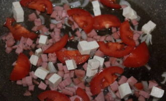 Voeg gesmolten kaas en tomaten toe, meng.