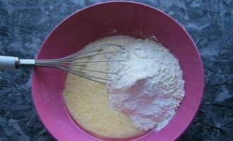 Cufunda masa uscata in chefir batut si oua. Începem să amestecăm produsul cu un tel până se sparg cocoloașele.