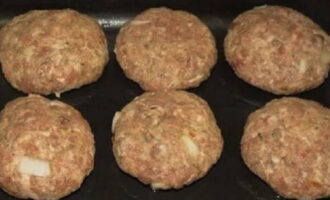 Maglagay ng maliit na mangkok ng tubig sa tabi ng lugar ng trabaho. Basain ang iyong mga kamay at kumuha ng isang medium-sized na piraso ng tinadtad na karne. Binubuo namin ang blangko. Kumuha kami ng isang baking sheet, ikalat ang papel dito at grasa ito ng langis. Ilatag ang mga cutlet.