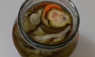 Häll saltlaken från en burk med pickles i grönsakerna.