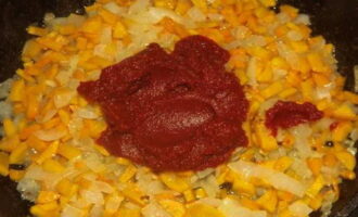 Untem la paella amb oli vegetal i posem al foc. Primer, sofregiu la ceba fins que estigui daurada. Afegiu-hi pastanagues i continueu remenant-ho tot suaument. Poseu una culleradeta de pasta de tomàquet a la paella. Ho deixem coure a foc lent juntament amb les verdures. 