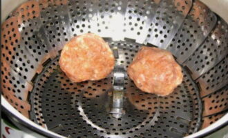 Col·loqueu les boles de carn preparades sobre una reixeta en una reixeta per a plats al vapor. Aboqueu mig litre d'aigua al bol multicooker. Col·loqueu el suport amb les costelles al multicooker i tanqueu-lo. 