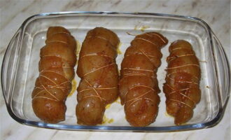 Kapag ang mga suso ay adobo, igulong ang mga ito sa mga rolyo at itali ng mahigpit sa sinulid. Ilagay muli sa refrigerator para sa 7-8 na oras.