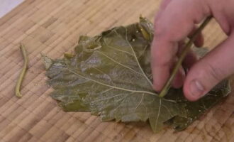 Låt oss gå vidare till att förbereda druvblad för dolma. Var noga med att skära av stjälkarna, tvätta dem noggrant från smuts och fyll dem med kokt vatten. Låt stå i 15 minuter.