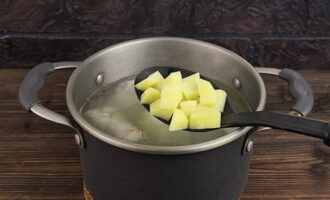 Lägg först potatiskuberna i pannan med kycklingbuljongen.