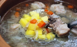 Kapag luto na ang sabaw, i-skim ang ibabaw kung kinakailangan at alisin ang bay leaves. Alisin ang karne mula sa kawali, alisin ito mula sa mga buto at gupitin ito sa katamtamang laki, pagkatapos ay ibalik ito sa sabaw. Balatan ang mga patatas, gupitin ang mga ito sa maliliit na cubes, ilagay ang mga ito sa sopas at patuloy na lutuin ang lahat sa mababang init. Gayundin sa yugtong ito, magdagdag ng asin at paminta sa panlasa.