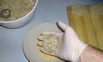 Van het resulterende gehakt vormen we kleine koteletten (dit is gemakkelijker te doen met handschoenen of handen gedrenkt in water) en rollen ze in paneermeel.