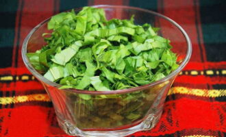 Banlawan ang sorrel nang lubusan sa ilalim ng tubig na tumatakbo, pilasin ang mga dahon mula sa mga petioles at makinis na tumaga sa mga piraso. Magdagdag ng pre-washed at tinadtad na perehil dito.