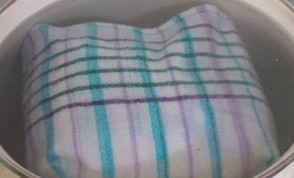 We sturen de bessen terug naar de pot en vullen ze met siroop. We verzamelen water in een aparte pan. Leg een handdoek op de bodem van de pan en plaats de pot. Breng op het fornuis het water in de pan aan de kook.