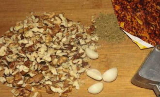 Rentar i pelar les nous. Els hem de triturar. Podeu fer-ho amb un ganivet o un martell de cuina. Si voleu que els fruits secs es notin clarament al gust del plat, piqueu-los ben petits, però no els convertiu en farina. Afegiu fruits secs a les verdures i la pasta de tomàquet. 