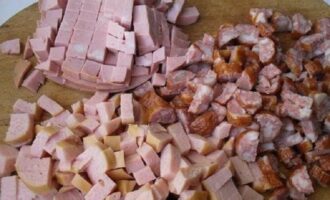 Snij de worst en kleine worstjes in grote blokjes en voeg toe aan de bouillon. Snij de worst en kleine worstjes in grote blokjes en voeg toe aan de bouillon.