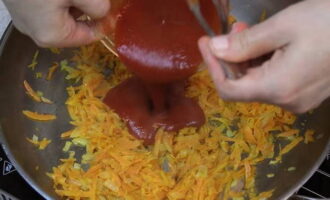 Piqueu la ceba i fregiu-la amb oli a la mateixa paella on abans s'havia escalfat la farina. Remeneu la ceba de tant en tant fins que quedi translúcida. Ratlleu les pastanagues en un ratllador gruixut i afegiu-les a la paella. Sofregiu a foc mitjà durant 4-5 minuts més, després reduïu el foc i afegiu-hi la pasta de tomàquet. 
