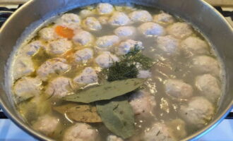 Afegiu les herbes picades i les fulles de llorer a la sopa. Cuini el plat a foc lent durant 15 minuts més.