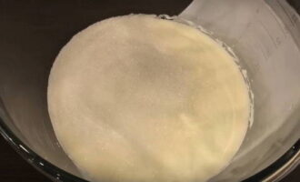 För att förbereda grädden, ta gräddfil, häll den i en skål och vispa med en mixer. Tillsätt socker och vispa igen tills den är slät, 2-3 minuter.