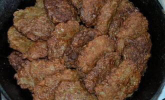 Després de fregir totes les costelles, transferiu-les a un bol profund (paella de ferro colat, olla d'ànec), afegiu-hi 2-3 cullerades. aigua i coure a foc lent tapat durant 10 minuts.