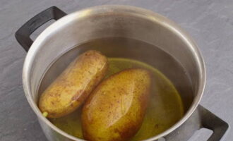 Bullir les patates amb la pell, refredar i ratllar-les amb un ratllador mitjà.