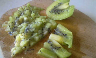 Com fer un batut amb gelat en una batedora a casa? Rentar bé el kiwi, pelar-lo i tallar-lo a trossos petits.