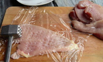 Talleu el filet longitudinalment en dues parts. Cobrir cada tros amb paper film i batre amb un martell de cuina.