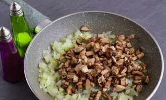 Rentar els xampinyons, picar i afegir a la paella amb les cebes, continuar sofregint 10 minuts més.
