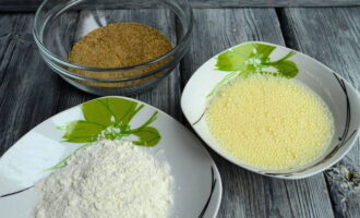 Prepareu els ingredients per a la massa. En un bol, bateu els ous de gallina amb el kefir, afegiu-hi el pa ratllat en un segon bol i enfarineu-lo en un tercer.