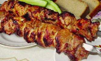 Rijg het gemarineerde vlees op spiesjes en leg het op de grill. Grill het vlees boven hete kolen en draai het af en toe. Zorg ervoor dat er geen open vuur is en dat het vlees gelijkmatig gaart. Serveer de afgewerkte shish kebab onmiddellijk op tafel.