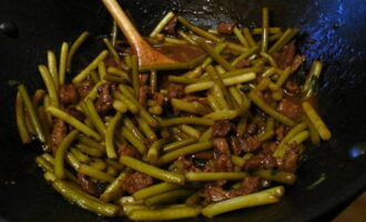 Després d'això, aboqueu la salsa preparada i porteu-la a ebullició. A continuació, reduïu el foc i deixeu coure el plat a foc lent durant 5 minuts.Com a resultat, tindreu brots d'all tendres amb trossos de carn en una salsa picant i dolça. 