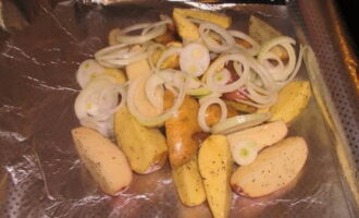 Takpan ang isang baking sheet na may foil upang makabuo ito ng maliliit na gilid. Ilagay ang patatas sa foil at ilagay ang binalatan at tinadtad na sibuyas sa ibabaw. 