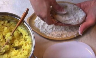 El puré s'ha de refredar, així que deixeu-lo durant 30 minuts a temperatura ambient. Després d'això, formeu costelles amb el puré. S'han d'enrotllar amb farina. Espolseu farina sobre una taula de tallar o un altre recipient i emboliqueu amb farina les dues cares. 