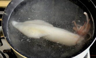 Hoe inktvis in zure roomsaus koken? Spoel de karkassen af ​​en doe ze in kokend water met een eetlepel zout. Je moet ze letterlijk een minuut koken en ze onmiddellijk uit het water halen. 