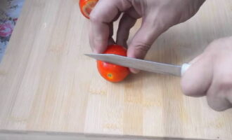 Cách nấu cà chua muối nhẹ với tỏi và rau thơm nấu nhanh? Chọn những quả cà chua đặc hơn và rửa sạch dưới vòi nước chảy. Lau bằng khăn bếp và cắt bỏ phần ngọn của mỗi quả. Bằng cách này, cùi cà chua sẽ thấm nước xốt và dưa chua tốt hơn. 