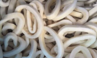 Com cuinar els calamars amb salsa cremosa? Preparem marisc. Les rentem amb aigua freda i les netegem. Per simplificar aquest procés, primer podeu posar el marisc en aigua calenta i després treure la pel·lícula amb un ganivet. Poseu els calamars en una cassola i cobriu-los amb aigua. Coure durant 5-7 minuts. Aquest pas és opcional, de manera que podeu saltar-lo amb seguretat. Talleu els calamars a anelles. Transferiu-los a un plat i reserveu-los.
