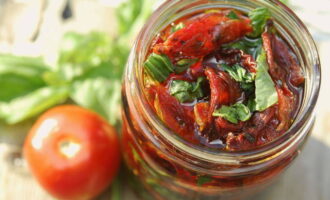 Puneți roșiile pregătite în recipiente sterilizate pregătite și turnați ulei vegetal fierbinte până acoperă complet legumele. Sigilați etanș și păstrați la frigider. 