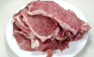 Paano magluto ng French pork meat na may keso at mga kamatis sa oven? Ang loin ay perpekto para sa ulam na ito, dahil ang karne mismo ay siksik at hawak nang maayos ang hugis nito at hindi naglalaman ng labis na taba, ngunit sapat na upang gawing makatas ang ulam. Gupitin ang baboy sa mga medalyon na 1-1.5 sentimetro ang kapal, asin at paminta sa magkabilang panig.