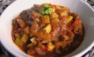 Deschideți cuptorul și scoateți tava. Se toarnă bucățile de roșii și se pune din nou tocana de carne înăuntru. Gatiti 10-15 minute.