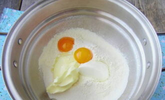 Paano maghurno ng masarap na blueberry pie sa oven? Salain ang harina sa isang mangkok, idagdag ang mga yolks, regular at vanilla sugar, asin, kulay-gatas at pinalambot na mantikilya.