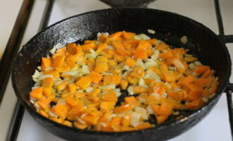 Schil de ui en snij in kleine blokjes. We schillen en snijden ook de wortels, maar in langwerpige reepjes. Op dit moment blijft de bouillon verzadigd van de smaak van vlees en zal deze binnenkort klaar zijn, en we verwarmen de koekenpan en smeren deze in met plantaardige olie. Bak er uien en wortels op. 