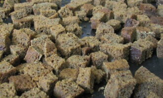 Col·loqueu els daus en una safata de forn i poseu-los al forn preescalfat a 180 °C. El pa s'ha d'assecar i enfosquir. 