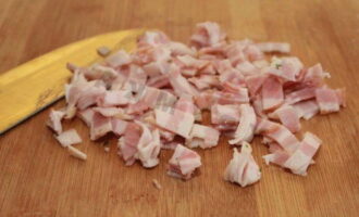 La cansalada s'ha de tallar a quadrats petits. La seva mida no ha de superar 1 centímetre. Poseu la paella al foc i deixeu-la escalfar. Lubriqueu-lo amb oli vegetal. També podeu utilitzar mantega. 