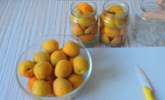 We kiezen abrikozen en leggen de verwende onmiddellijk opzij. Het is belangrijk om rijp en niet overrijp fruit achter te laten. Was de abrikozen goed en laat ze uitlekken op keukenpapier of servetten. Plaats de geselecteerde abrikozen in een gesteriliseerde pot. 