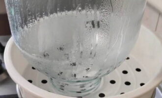 In eerste instantie wassen we de potten samen met frisdrank en steriliseren ze pas daarna gedurende 10 minuten met stoom. We herhalen hetzelfde met de deksels.