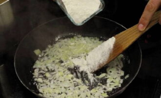 Voeg de bloem toe en bak nog een minuutje. Voeg hierna de tomatenpuree toe en bak 4 minuten. roeren. 