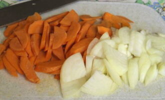 Cum să gătești tocană de legume cu dovlecei, varză și cartofi? Pregătiți imediat toate ingredientele pentru tocană conform rețetei. Curățați și clătiți legumele. Tăiați ceapa în sferturi de inele, iar morcovii în semicercuri subțiri, deși forma tăierii legumelor poate fi arbitrară, dar aproximativ aceeași.
