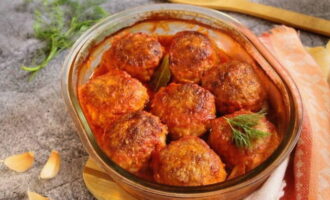 Als de gehaktballetjes klaar zijn, haal je de bakplaat uit de oven en leg je de gehaktballetjes in de pan met de tomatensaus. Laat afgedekt op laag vuur ongeveer 10-15 minuten sudderen. Serveer op tafel samen met een bijgerecht. 