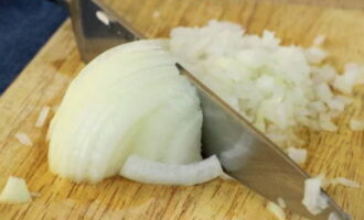 Esbandida la ceba amb aigua freda. Peleu les closques i torneu-les a rentar. Talleu la ceba a trossos petits. Posa-ho en un plat. Peleu els alls i espremeu-los per una premsa. Afegiu al plat amb la ceba picada. 