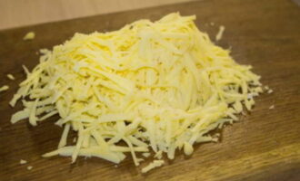 Ratlleu el formatge amb un ratllador fi. Afegiu-ho a la salsa i remeneu-ho. Fregueu o premeu els alls amb una premsa. Afegiu-ho a la salsa i torneu a remenar. 