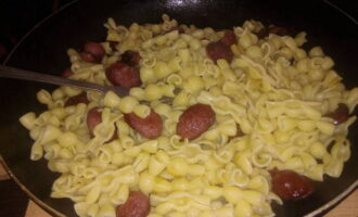 Doe de gekookte pasta in de pan met de vleesproducten en roer. Verwarm het gerecht op laag vuur en breng op smaak met peper. Het gerecht is klaar! Serveer onmiddellijk terwijl het warm is. Voeg eventueel ketchup of mayonaise toe.
