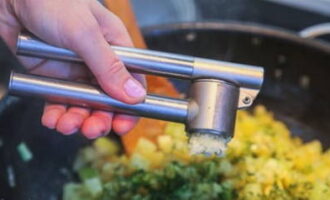 Zout en peper het voedsel. Hier persen we de knoflookteentjes door een pers en voegen gehakte kruiden toe. Roer en laat nog 20 minuten op laag vuur sudderen.