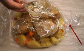 După acest timp, puneți legumele marinate cu carne în manșonul de copt pregătit.